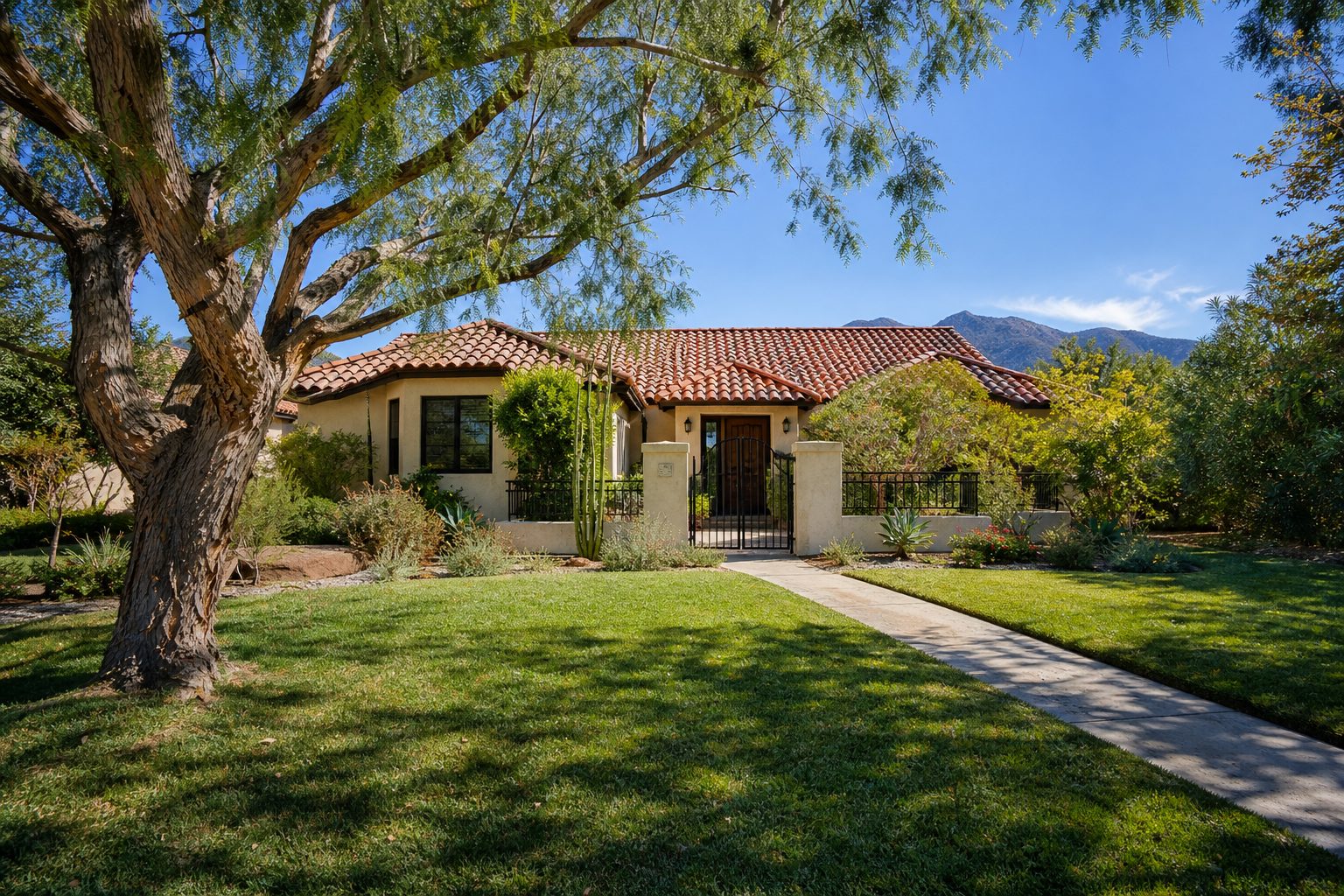 Single-family home in Granada Hills with mature pepper tree, clay tile roof, and established California native landscaping in bright sunlight.